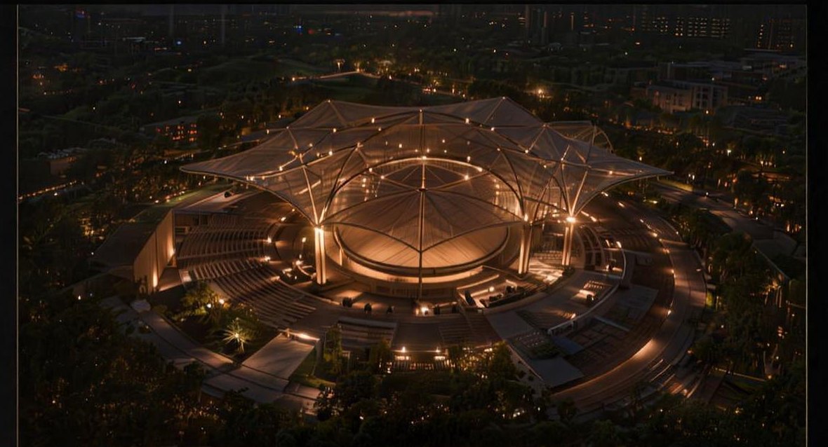 The First Light Theatre from above at night — the woven canopy glowing amid the city darkness